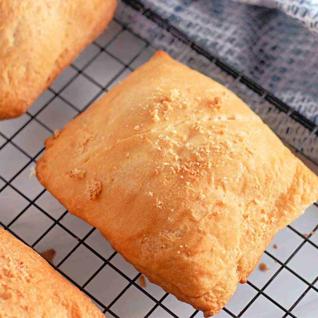 closeup of golden brown baked crescent pockets on a cooling rack
