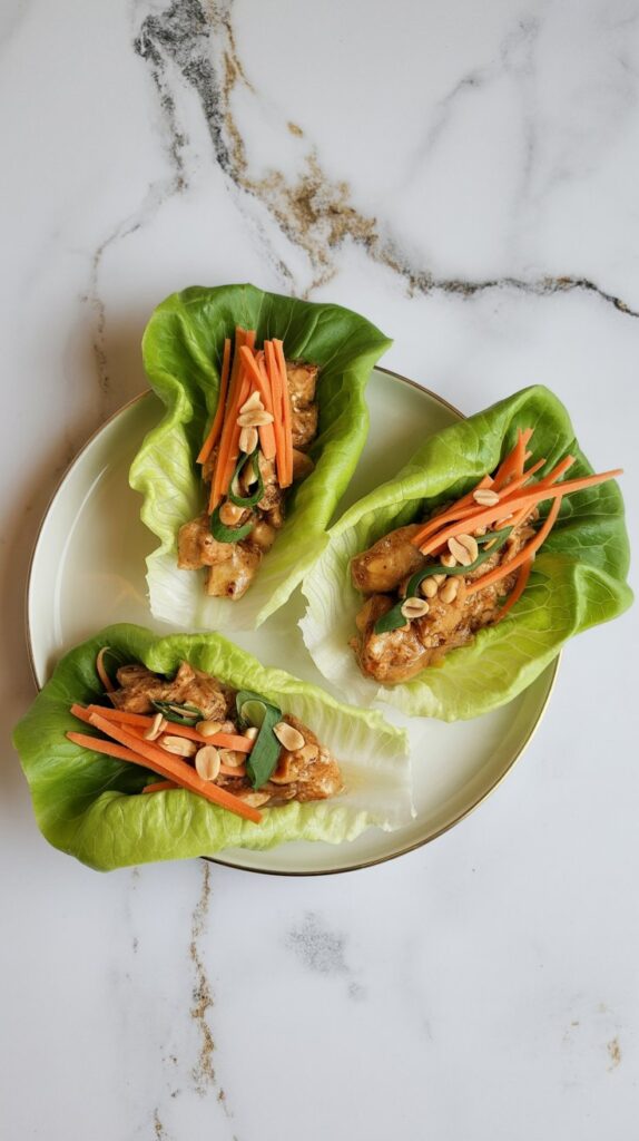 Thai peanut chicken lettuce wraps with shredded carrots and peanuts in butter lettuce