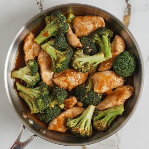 a chicken and broccoli stir-fry in a skillet with glossy garlic soy sauce