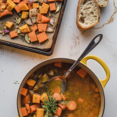 A top view of a pan of cubed butternut squash and pan of roasted butternut squash soup with spoon inside.