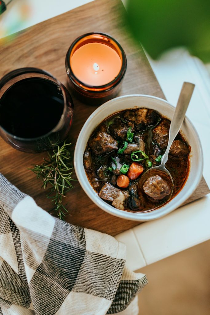 Bowl of slow-cooked beef stew with vegetables and fresh herbs