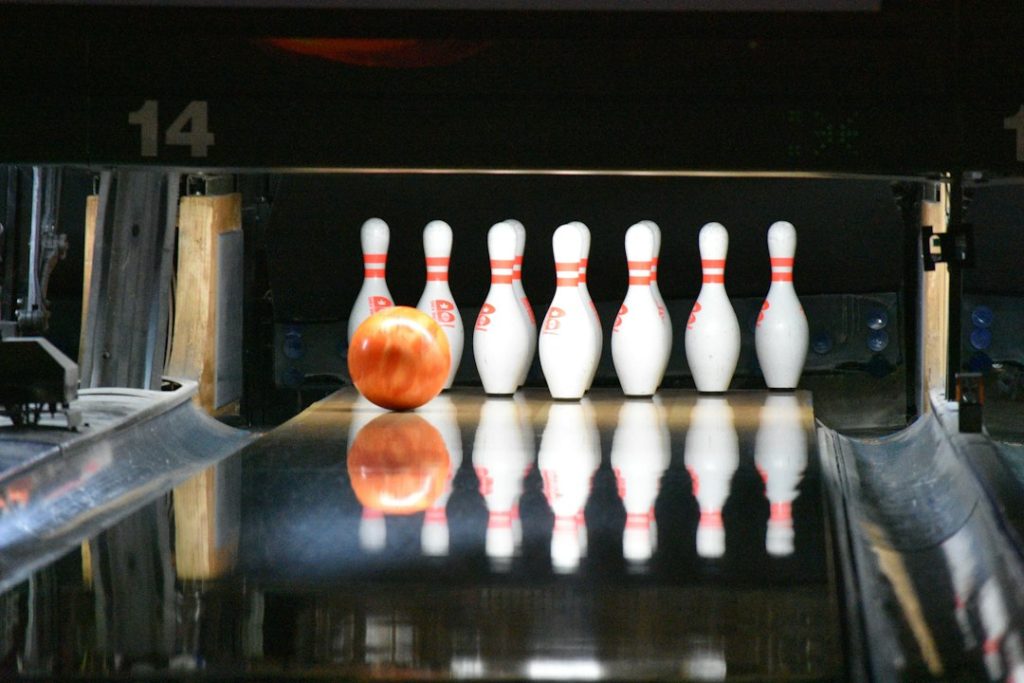 Bowling ball rolling toward a set of white bowling pins