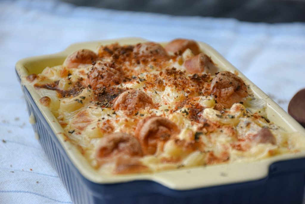 Cheesy salmon pasta bake with a golden top in a blue baking dish