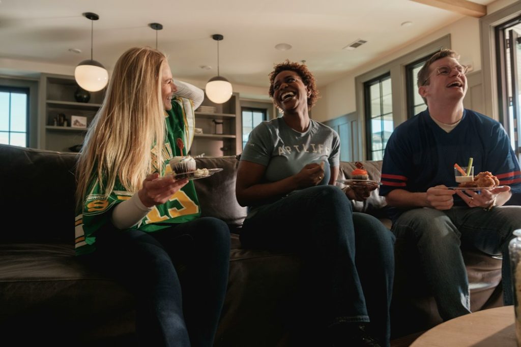 Friends laughing together on a couch in a living room