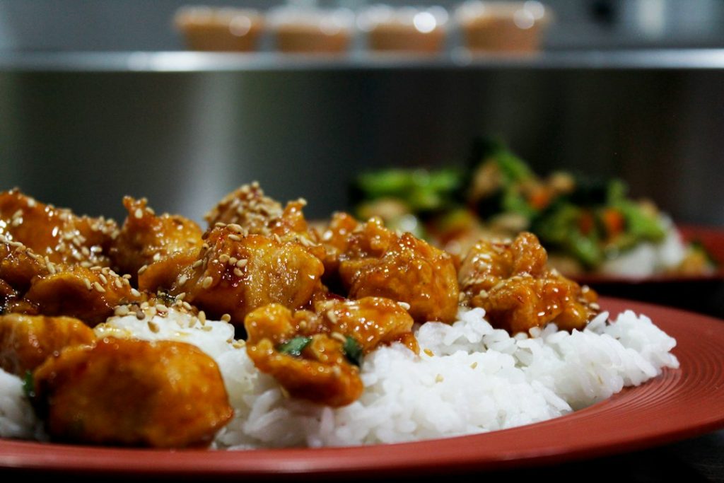 Glazed teriyaki-style chicken pieces topped with sesame seeds served over white rice