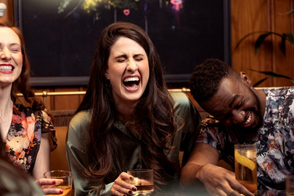 Group of friends laughing together at a table with drinks