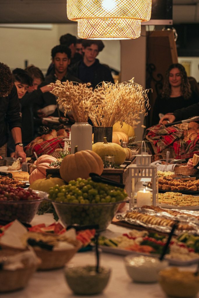 Guests gathered around a festive table full of fall food and pumpkins