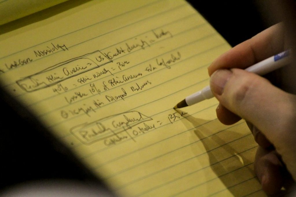 Hand writing answers on a yellow legal pad
