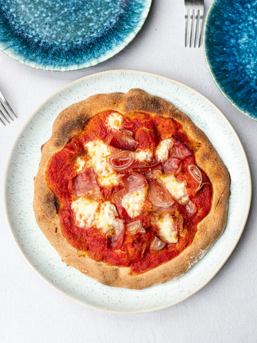 Homemade pizza with salami and melted mozzarella