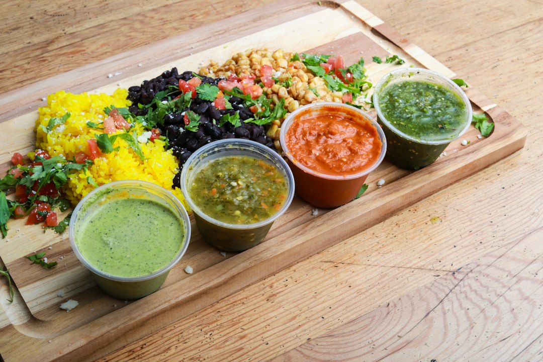 Homemade sauces in small cups next to a rice bowl