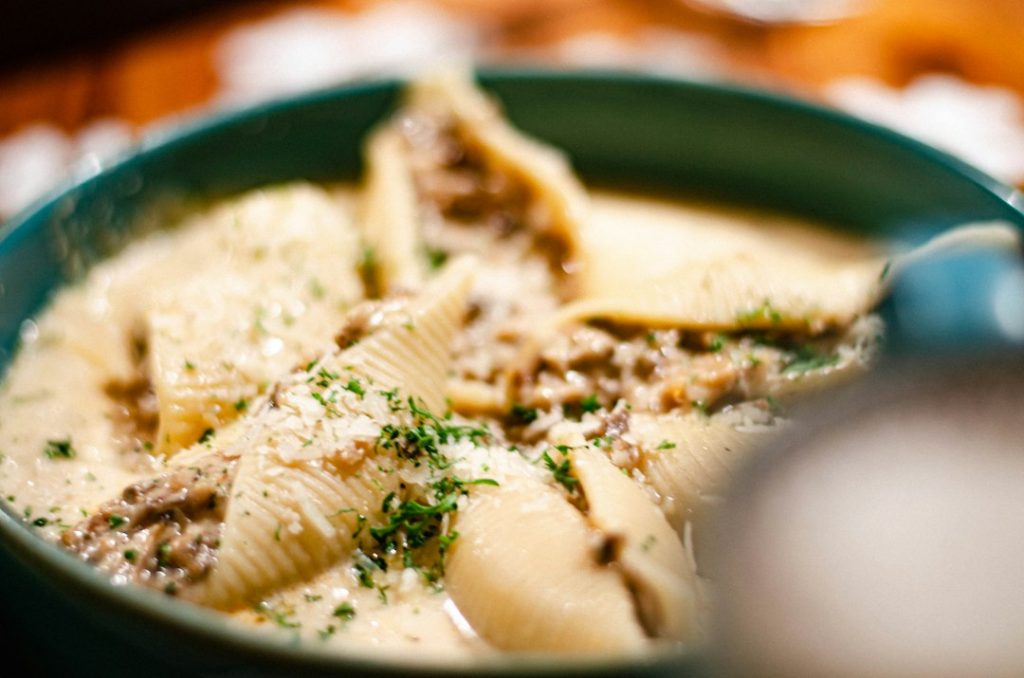 Stuffed jumbo pasta shells in a creamy sauce topped with herbs