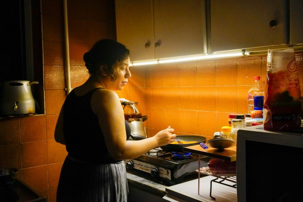 Woman cooking dinner at the stove in a small home kitchen