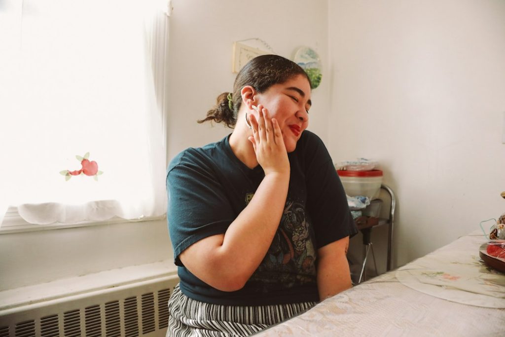 Woman resting her face in her hand at the kitchen table
